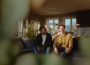 zwei Männer sitzen lachend auf der Couch